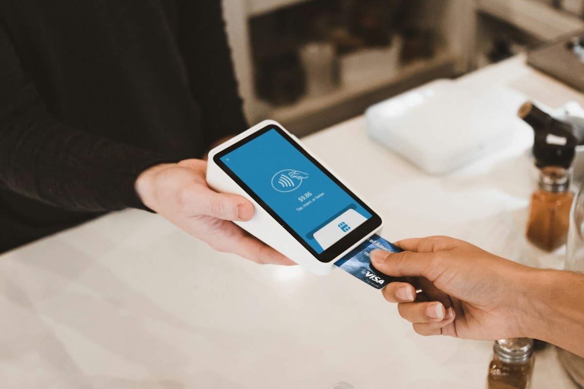 Customer paying by card on a smart terminal at a cafe